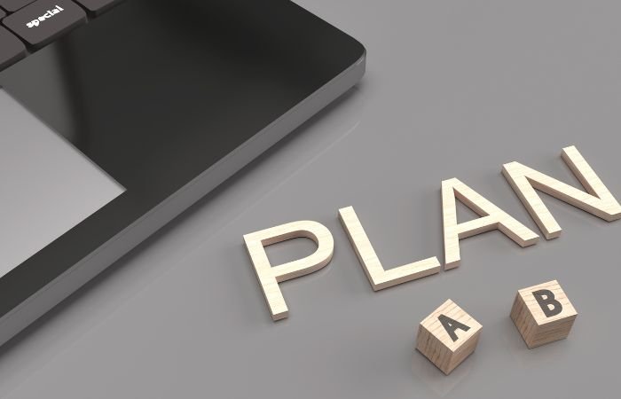small fraction of a PC & the word 'plan' spelt with individual letters on a work desk
